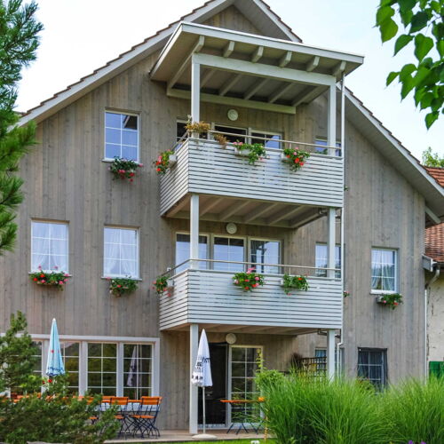 Gedeckter Balkon und Sitzplatz mit Holzdeck